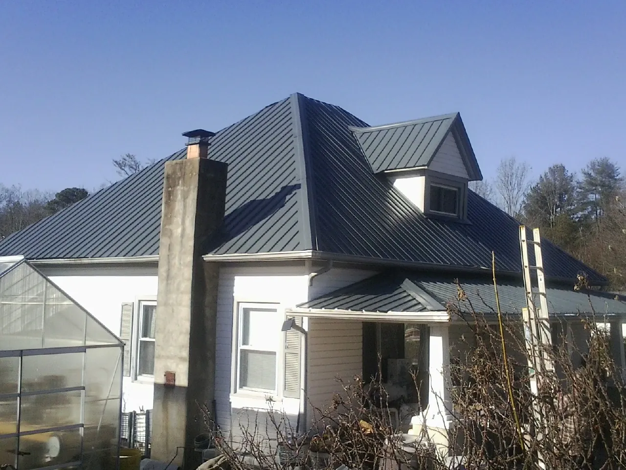 Dark blue standing seam metal roof on a white farmhouse with dormer — Slate & Tile Roof Repair by Roofing Brothers in Peotone
