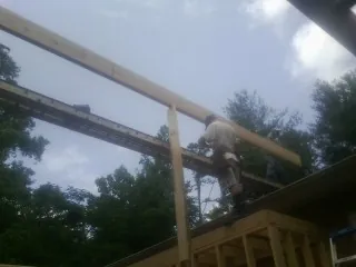 Carpenter setting a ridge beam over a new addition frame — Ice Dam Removal by Roofing Brothers in Peotone