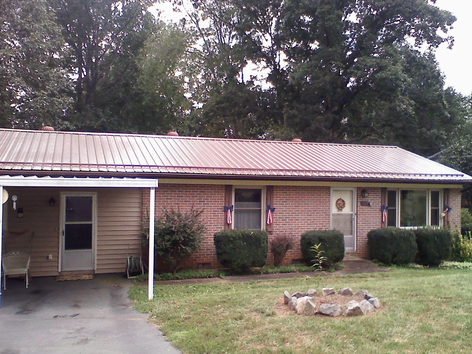 Bronze metal roof and carport on a brick ranch home — Roof Repair work by our crew in Peotone